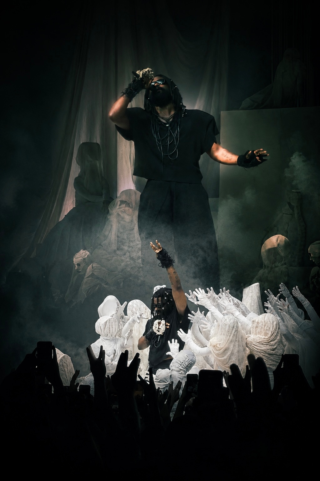 Theatrical stage performance with smoke and figures in white